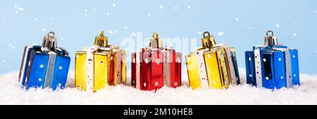 Dekorationen für den Weihnachtsbaum in Form von Geschenkboxen in Rot, Blau und Gelb. Weihnachtsbanner Stockfoto