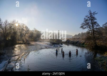 Schwimmer trotzen dem Wasser im Fluss Avon in Warleigh Weir bei Bath in Somerset heute Morgen, als die Temperaturen über Großbritannien sinken. Stockfoto