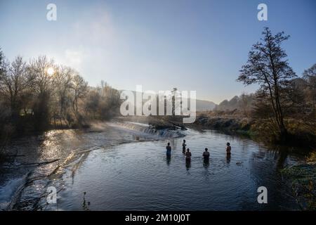 Schwimmer trotzen dem Wasser im Fluss Avon in Warleigh Weir bei Bath in Somerset heute Morgen, als die Temperaturen über Großbritannien sinken. Stockfoto