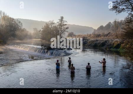 Schwimmer trotzen dem Wasser im Fluss Avon in Warleigh Weir bei Bath in Somerset heute Morgen, als die Temperaturen über Großbritannien sinken. Stockfoto