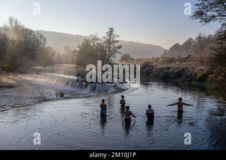 Schwimmer trotzen dem Wasser im Fluss Avon in Warleigh Weir bei Bath in Somerset heute Morgen, als die Temperaturen über Großbritannien sinken. Stockfoto