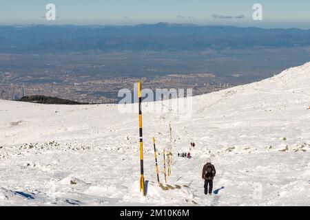 Wanderer steigen auf einem Wanderweg vom Black Peak Summit auf 2290 m Höhe im Vitosha Mountain mit Blick auf Sofia, Bulgarien und Osteuropa ab Stockfoto