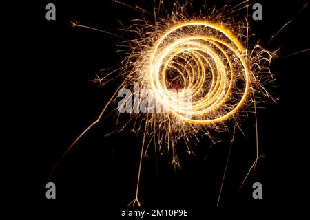 Kreise mit Funken auf schwarzem Hintergrund. Festliche Glitzer, abstrakte Silvesterlichter Stockfoto