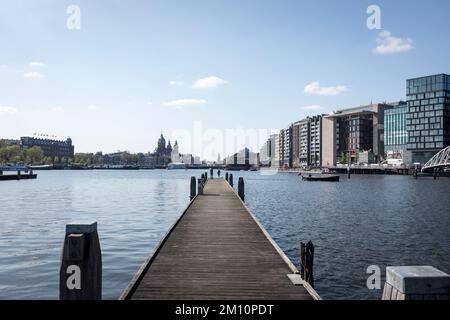 Ein Blick entlang einer der langen Anlegestellen am Oosterdok in Amsterdam, Niederlande. Stockfoto