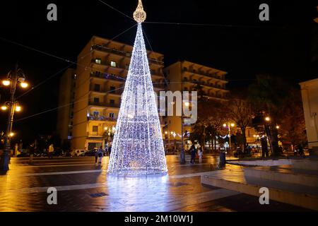 Pagani, Salerno, Italien. 8.. Dezember 2022. Pagani, Salerno, Italien - 08. Dezember 2022 : Festmahl der unbefleckten Empfängnis. Die unbefleckte Empfängnis von Maria wurde 1854 offiziell mit einem päpstlichen Stier, unterzeichnet von Papst Pius IX. Mit dem Titel Ineffabilis Deus, mit dem festgestellt wurde, dass die Mutter Jesu rein geboren wurde und in der Gebärmutter völlig frei von Sünde und daher makellos empfangen wurde. Es ist die Party, die die Weihnachtszeit beginnt. Ein Zwerg und zwei Zeichentrickfiguren animieren Kinder in der Nähe des Weihnachtsbaums. (Kreditbild: © Pasquale Senatore/Pacific Press via ZUMA Pre Stockfoto