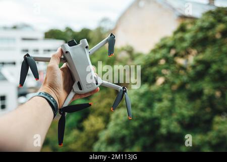 Ein selektiver Fokus einer Hand, die eine kleine Lichtdrohne im Freien hält Stockfoto