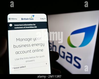 Person, die ein Smartphone mit einer Webseite des Energieunternehmens British Gas auf dem Bildschirm vor dem Unternehmenslogo hält. Konzentrieren Sie sich auf die Mitte des Telefondisplays. Stockfoto