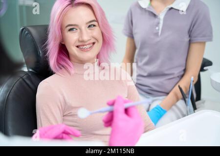 Junge Frau lächelt liebevoll zum Arzt Stockfoto