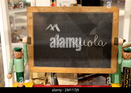 Oldtimer-Spielzeug einer Tafel mit Inschrift auf Italienisch "Down with School" Stockfoto