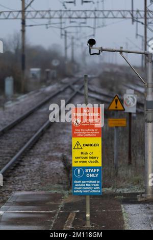 Warnschilder am Ende des Bahnsteigs am Bahnhof Leigh on Sea, Essex, Großbritannien. Kein Betreten. Gefahr, Gefahr von schweren oder tödlichen Verletzungen. Nur Personal. Frostige Morgendämmerung Stockfoto