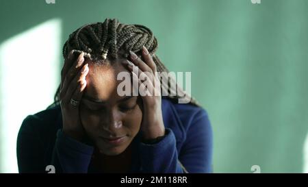 Eine ängstliche junge schwarze Frau, die sich Sorgen macht. Gestresstes afroamerikanisches Latina erwachsenes Mädchen, das zu Hause psychisch krank ist Stockfoto