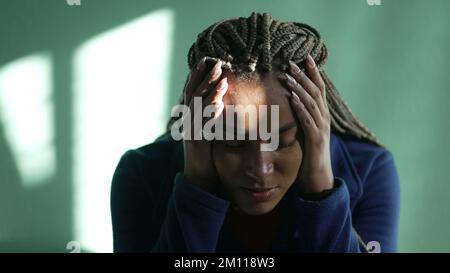 Eine ängstliche junge schwarze Frau, die sich Sorgen macht. Gestresstes afroamerikanisches Latina erwachsenes Mädchen, das zu Hause psychisch krank ist Stockfoto