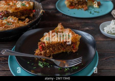 Ein Stück Hackfleischpastete auf einem Holztisch. Nahaufnahme und Vorderansicht Stockfoto