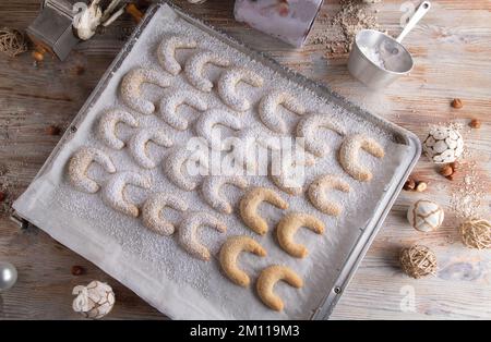 Frisch gebackene weihnachtskekse auf silberfarbenem Backblech. Vanillekipferl. Flach verlegt Stockfoto