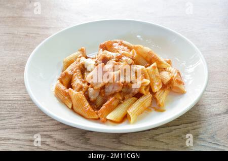 penne Pasta-Belag Schweinefleisch bologna Dressing gebratenes Schweinefleisch in Ketchup und Käsesauce auf dem Teller Stockfoto