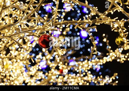 Festliche Lichter im Hintergrund des Weihnachtsbaums. Neujahrsdekoration auf der Winterstraße Stockfoto