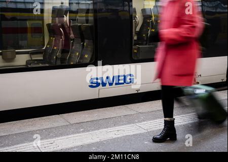 Stuttgart, Deutschland. 09.. Dezember 2022. Die Leute gehen an einem Zug mit dem SWEG-Logo vorbei. Triebwerkfahrer von GDL kündigten neue Streiks bei der Eisenbahngesellschaft SWEG an. Kredit: Ilkay Karakurt/dpa/Alamy Live News Stockfoto