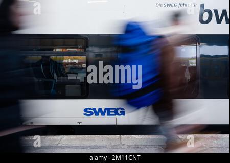 Stuttgart, Deutschland. 09.. Dezember 2022. Die Leute gehen an einem Zug mit dem SWEG-Logo vorbei. Triebwerkfahrer von GDL kündigten neue Streiks bei der Eisenbahngesellschaft SWEG an. Kredit: Ilkay Karakurt/dpa/Alamy Live News Stockfoto