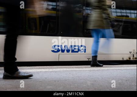 Stuttgart, Deutschland. 09.. Dezember 2022. Die Leute gehen an einem Zug mit dem SWEG-Logo vorbei. Triebwerkfahrer von GDL kündigten neue Streiks bei der Eisenbahngesellschaft SWEG an. Kredit: Ilkay Karakurt/dpa/Alamy Live News Stockfoto