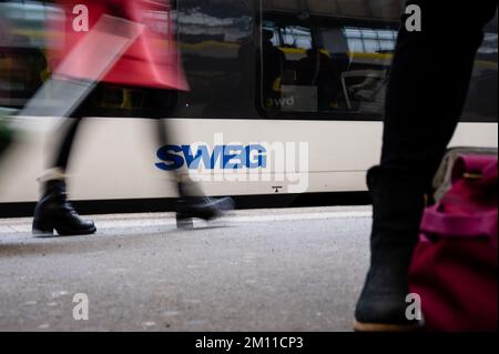 Stuttgart, Deutschland. 09.. Dezember 2022. Die Leute gehen an einem Zug mit dem SWEG-Logo vorbei. Triebwerkfahrer von GDL kündigten neue Streiks bei der Eisenbahngesellschaft SWEG an. Kredit: Ilkay Karakurt/dpa/Alamy Live News Stockfoto