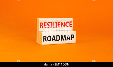 Roadmap-Symbol für Resilienz. Konzeptbegriff „Resilience“-Roadmap auf Holzblöcken getippt. Schöner orangefarbener Tischhintergrund. Business und Resilienz r Stockfoto