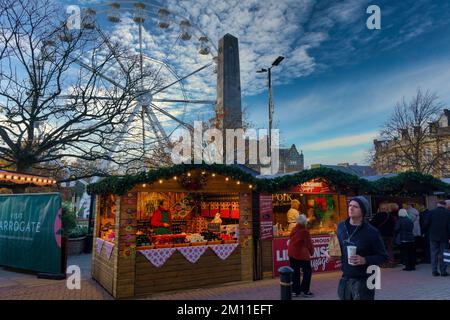 Besitzer von Verkaufsständen, die Lebensmittel neben dem Cenotaph in einer Fußgängerzone mit einem großen Riesenrad verkaufen, Harrogate, North Yorkshire, England, Großbritannien. Stockfoto