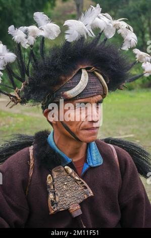 West Siang, Arunachal Pradesh, Indien - 02 22 2013 : Außenportrait des Stammesmannes Adi Minyong mit Tigerkiefer und traditionellem Kriegshauptschmuck Stockfoto