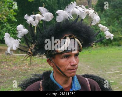West Siang, Arunachal Pradesh, Indien - 02 22 2013 : Porträt eines Mannes des Adi-Minyong-Stammes, der traditionellen Kriegshauptschmuck mit Federn trägt Stockfoto