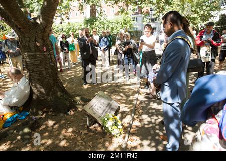 Bürgermeister von Camden, Cllr Nasim Ali, beobachtet eine Stille in der Nähe des Kirschbaums, der zum Gedenken an die Opfer von Hiroshima während einer Veranstaltung in London gepflanzt wurde. Stockfoto