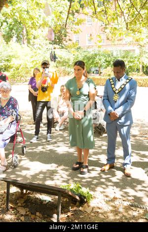 Bürgermeister von Camden, Cllr Nasim Ali, beobachtet eine Stille in der Nähe des Kirschbaums, der zum Gedenken an die Opfer von Hiroshima während einer Veranstaltung in London gepflanzt wurde. Stockfoto