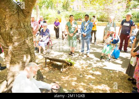 Bürgermeister von Camden, Cllr Nasim Ali, beobachtet eine Stille in der Nähe des Kirschbaums, der zum Gedenken an die Opfer von Hiroshima während einer Veranstaltung in London gepflanzt wurde. Stockfoto