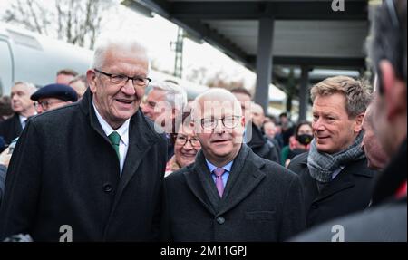 Stuttgart, Deutschland. 09.. Dezember 2022. Winfried Kretschmann (von links, Bündnis 90/die Grünen), Ministerpräsident von Baden-Württemberg, Michael Theurer (FDP), Bundeskommissar für Schienenverkehr, und Richard Lutz, CEO der Deutschen Bahn AG, stehen auf einem Bahnsteig am Hauptbahnhof Stuttgart während der Sonderreise zur Eröffnung der neuen Eisenbahnstrecke Wendlingen-Ulm. Von Stuttgart aus fährt ein besonderer EISZUG mit geladenen Gästen auf der neuen Strecke von Stuttgart nach Ulm. Kredit: Bernd Weißbrod/dpa/Alamy Live News Stockfoto