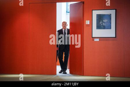 Berlin, Deutschland. 09.. Dezember 2022. Bundeskanzler Olaf Scholz (SPD) verlässt sein Büro, um Verwandte von Bundeswehrsoldaten und Polizeibeamten im Ausland aufzunehmen. Rechts hängt ein Porträt von Konrad Adenauer, dem ersten deutschen Kanzler. Kredit: Kay Nietfeld/dpa/Alamy Live News Stockfoto