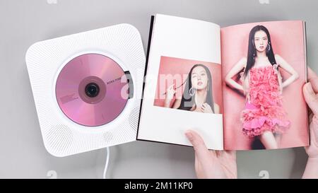 Fanhänger halten BlackPink BORN PINK 2. Album Fotobuch mit Jisoo auf Grau. Pinkfarbene Musik-CD im Player. Südkoreanische Mädchengruppe BlackPink. Platz für t Stockfoto