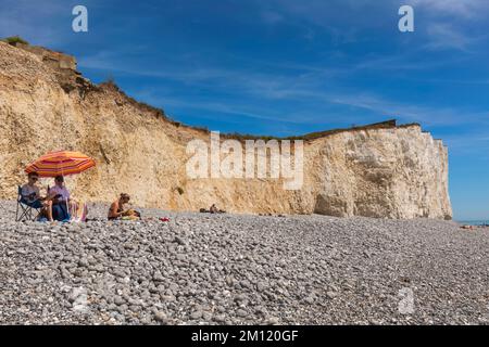 England, East Sussex, Eastbourne, The Seven Sisters Cliffs, The Birling Gap, Familie mit buntem Sonnenschirm Entspannen am Strand Stockfoto