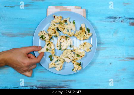 Gebratene Blumenkohlscheiben, Petersilie. Gesunde Ernährung, pflanzliche Ernährung. Vegetarische Bio-Lebensmittel. Stockfoto