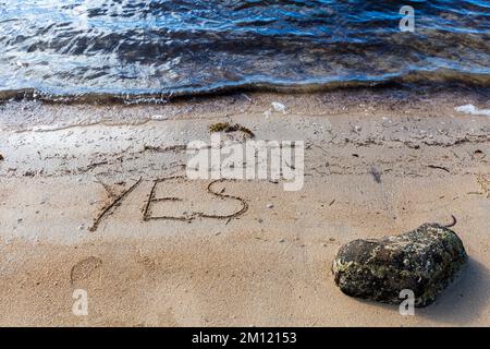 Ja - wie eine Nachricht mit einem Finger im Sand geschrieben an einem Strand mit Wellen und blauem Ozean auf Mauritius Island, Afrika, Draufsicht, niemand Stockfoto