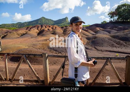 Junge europäische Dame vor einer der Hauptattraktionen von Mauritius - einzigartiger Nationalpark Chamarel, der die Erde mit den „glatten Farben“ bedeckt Stockfoto