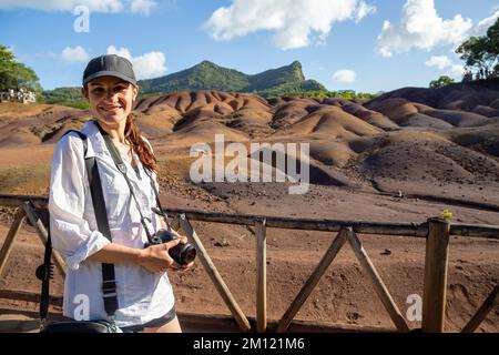 Junge europäische Dame vor einer der Hauptattraktionen von Mauritius - einzigartiger Nationalpark Chamarel, der die Erde mit den „glatten Farben“ bedeckt Stockfoto