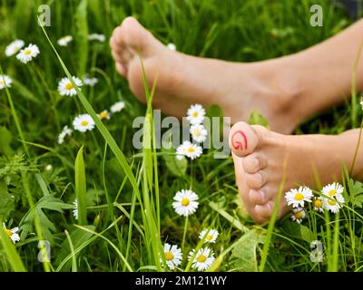 Barfußlaufen - Nahaufnahme der Frauenfüße mit Zone auf dem großen Zeh (Hallux) für Reflexzonenmassage Stockfoto