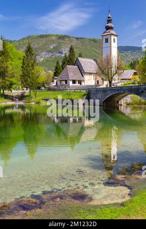 Kirche St. Johannes der Täufer und die Steinbrücke am Bohinj-See. Bohinj Lake, Slowenien, Europa. Stockfoto