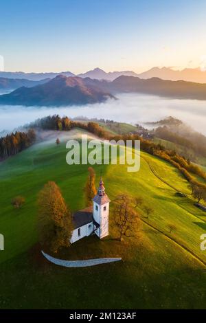 Die Kirche St. Thomas bei Sonnenaufgang im Herbst aus der Vogelperspektive. Sveti Tomaz, Skofja Loka, Oberkarniola, Slowenien, Europa. Stockfoto