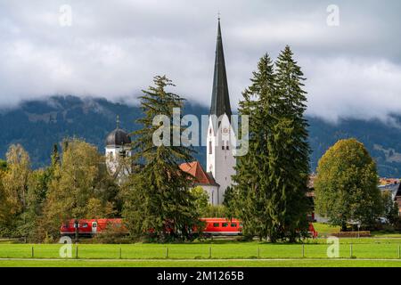 Regionalzug vor der Lady Chapel und der Kirche St. Verena in Fischen Stockfoto