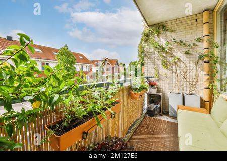 Ein Balkon mit Pflanzen und Topftöpfen an der Außenwand, mit Blick auf die Straße von der Terrasse Stockfoto