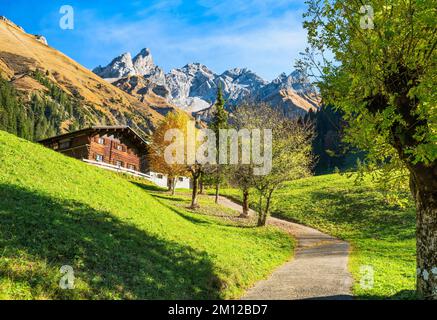 Altes Bauernhaus am sonnigen Herbsttag. Einödsbach mit Trettachspitze, Mädelegabel und Hochfrottspitze. Allgäu Alps, Bayern, Deutschland, Europa Stockfoto