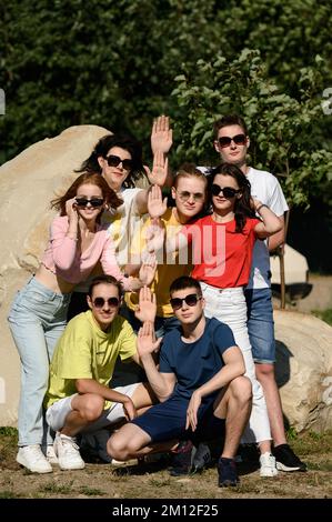 Ivano-Frankivsk, Ukraine, 14. Juli 2022: Teenager im Schulalter posieren für ein Foto auf dem Sportplatz, Kinder mit ihrem Lehrer. Stockfoto