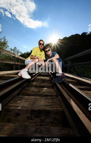 Ivano-Frankivsk, Ukraine 14. Juli 2022: Foto von zwei Teenagern auf einer Eisenbahnbrücke. Eine Fotosession in der Schule. Stockfoto