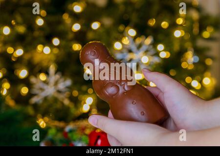 Das Kind hält Schokoladenfiguren in Form eines Schneemanns. Stockfoto