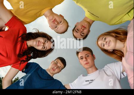 Ivano-Frankivsk, Ukraine, 14. Juli 2022: Glückliche Kinder machten einen Kreis mit ihren Köpfen, leuchtende Farben der Kinderkleidung. Stockfoto