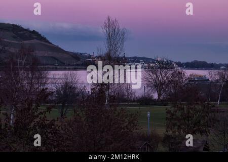Bingen am Rhein - 10. Januar 2021: Farbenfroher rosa und blauer Himmel über dem Rhein an einem Winterabend in Deutschland. Stockfoto